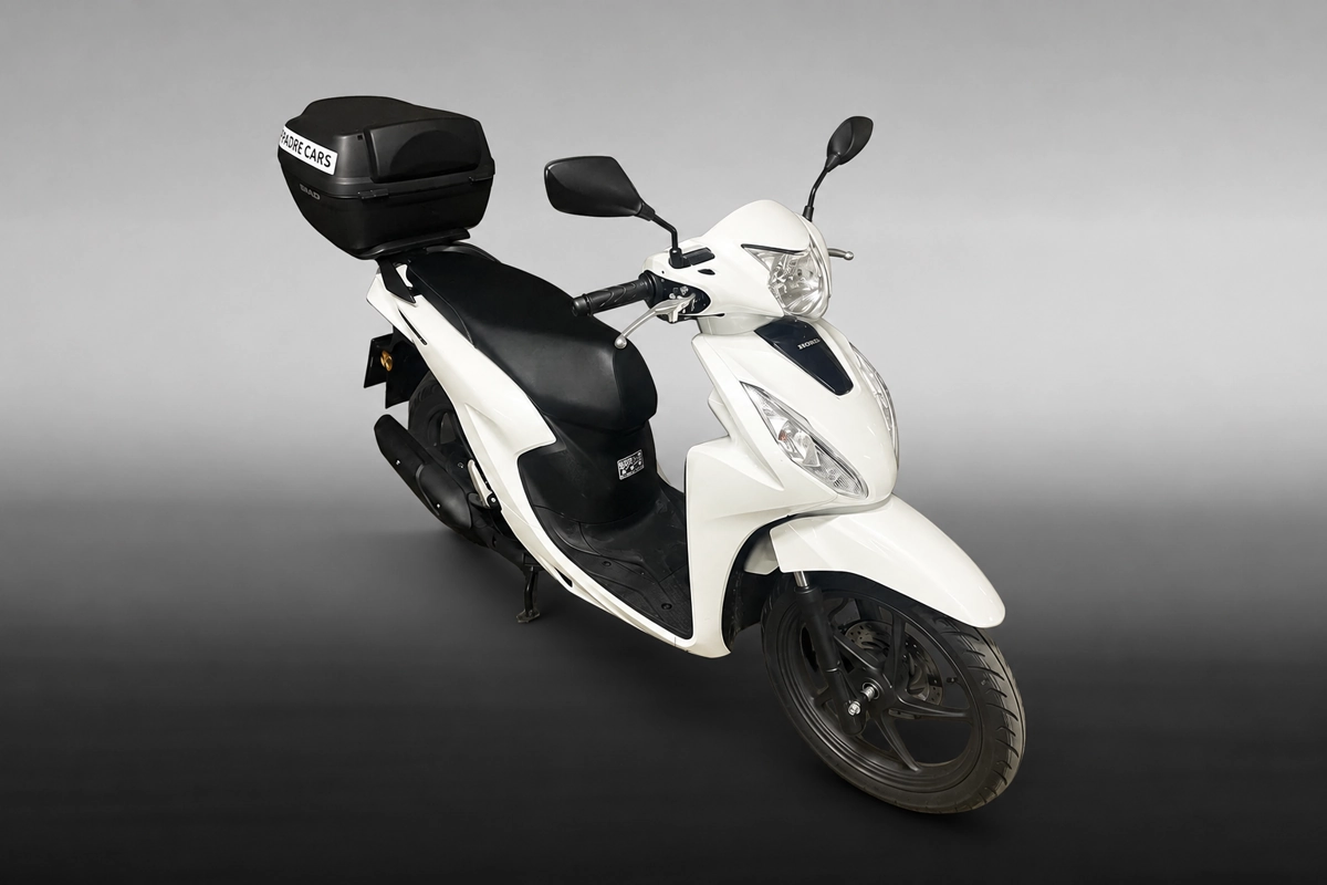 Bílý skútr Honda Vision s úložným boxem